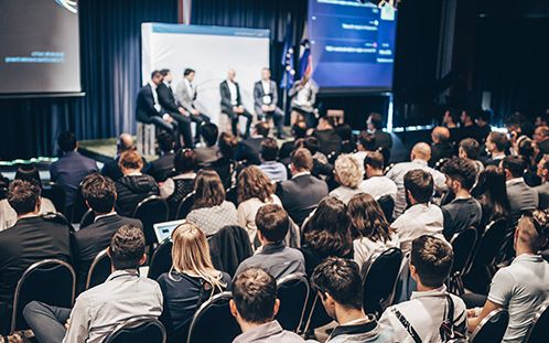 A conference audience watching a panel discussion on stage