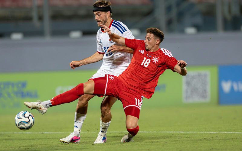 A Malta national team player stretching for the ball in a home match